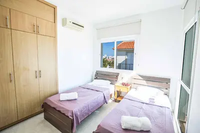 two beds in a room with a window at Villa Mesogeios ME25 in Protaras