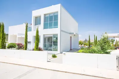 a white house with trees in front of it at Protaras Greco Villa CCV2 in Protaras
