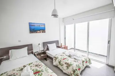 a bedroom with two beds and a large window at Protaras Greco Villa CCV2 in Protaras