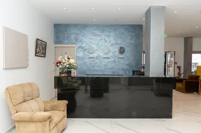 a salon with a reception desk and a chair at Flora Hotel Apartments in Protaras