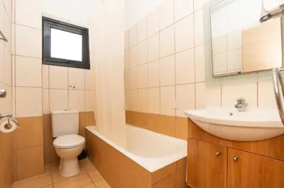 a bathroom with a sink and a toilet and a tub at Flora Hotel Apartments in Protaras