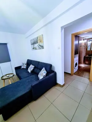 a blue couch sitting in a living room at Ayia Anna Apartment in Ayia Napa