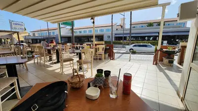 a restaurant patio with tables and chairs and a building at Ayia Napa sea view great location bars & beach in Ayia Napa
