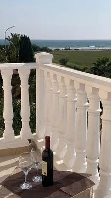 a bottle of wine and two glasses on a balcony at Sunset Sea View Villa in Ayia Napa