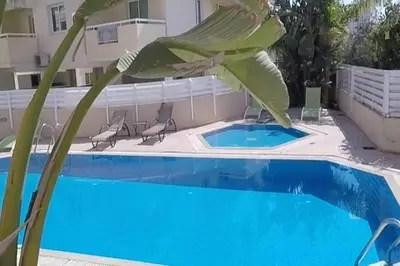 a large plant next to a swimming pool at Andros Apt 2 Bed, Free Wi-fi, Safe, Complex Pool in Paralimni