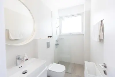 a white bathroom with a sink toilet and a mirror at Protaras Olivine Villa Ol9 in Protaras