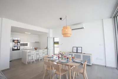 a kitchen and dining room with a table and chairs at Protaras Olivine Villa Ol10 in Protaras