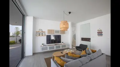 a living room with a couch and a tv at Protaras Olivine Villa Ol10 in Protaras