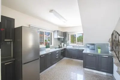 a kitchen with black cabinets and a stainless steel refrigerator at Protaras Holiday Villa Dv16 in Protaras