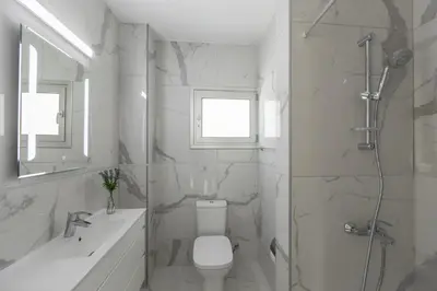 a white bathroom with a toilet and a shower at Protaras Sunrise Beach Villa 2 in Protaras