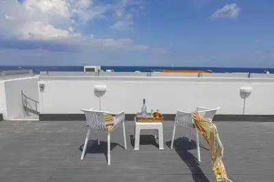 a table and chairs on a roof with the ocean at Protaras Sunrise Beach Villa 2 in Protaras