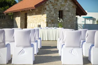 a row of white chairs in front of a building at The Quality Lodge - Self Check-in in Voroklini