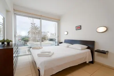 a bedroom with a bed and a large window at Coralli Spa Resort Protaras Stylish 1 Bedroom apartment in Protaras