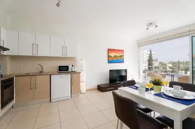 a kitchen and dining room with a table and chairs at Coralli Spa Resort Protaras Stylish 1 Bedroom apartment in Protaras