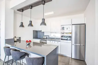 a kitchen with a refrigerator and a table with chairs at Villa Olivine Pearl 6 in Protaras