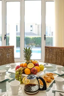 a table with a bunch of fruits and pastries on it at Cape Greco Villa Anastel 2 in Ayia Napa