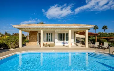 a villa with a swimming pool in front of a house at Cape Greco Villa Anastel 2 in Ayia Napa