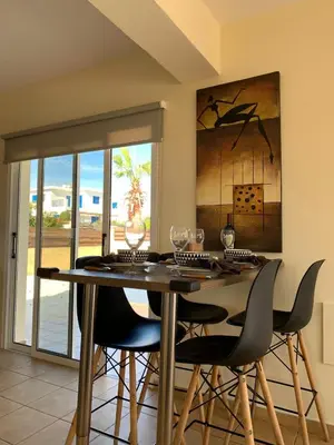 a dining room with a table and four chairs at Moonlight Sea View Villa in Ayia Napa