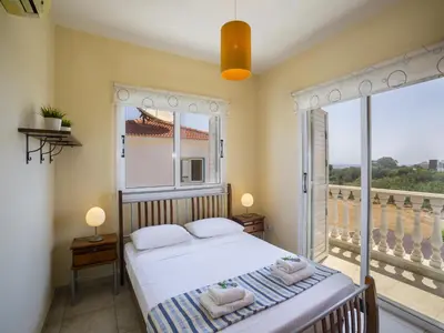 a bedroom with a bed and a large window at Protaras Villa Amber By The Sea in Protaras