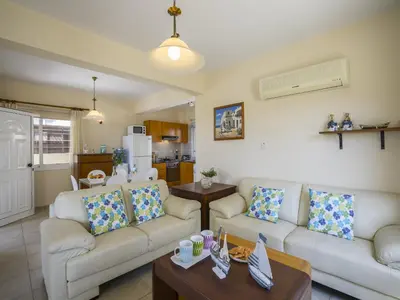 a living room with two couches and a kitchen at Protaras Villa Amber By The Sea in Protaras