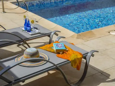 a table with a birthday cake on it next to a pool at Protaras Villa Amber By The Sea in Protaras