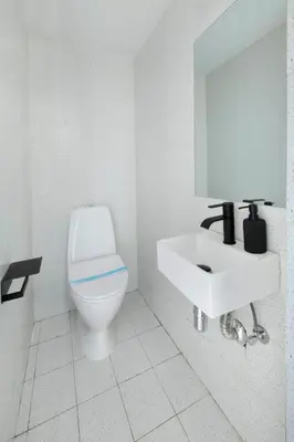 a white bathroom with a toilet and a sink at Urban Condo Promitheos in Nicosia
