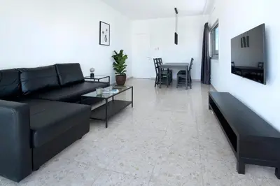 a living room with a black couch and a table at Urban Condo Promitheos in Nicosia