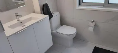 a white bathroom with a toilet and a sink at Ellas Modern Duplex City Center in Nicosia