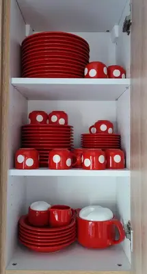 a bunch of red bowls and plates on shelves at Ellas Modern Duplex City Center in Nicosia