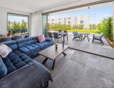 a living room with a blue couch and a table at Azure Villas by Marc in Protaras
