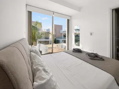 a white room with a couch and a large window at Azure Villas by Marc in Protaras