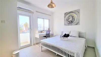 a bedroom with a bed and a desk and a window at Coastal Getaway: 2 Apartments for up to 14 guests! Light-flooded and Spacious in Larnaka