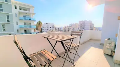 a table and chairs on a balcony with a view at Coastal Getaway: 2 Apartments for up to 14 guests! Light-flooded and Spacious in Larnaka
