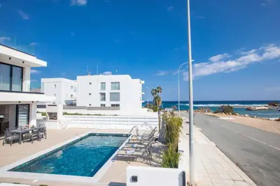 a house with a swimming pool next to the beach at Protaras Holiday Villa TI39 in Paralimni