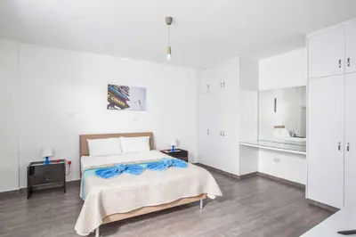 a white bedroom with a bed and a mirror at Protaras Greco Villa CCV5 in Protaras