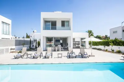 a villa with a swimming pool in front of a house at Protaras Greco Villa CCV5 in Protaras