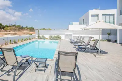 a group of chairs sitting next to a swimming pool at Protaras Greco Villa CCV5 in Protaras