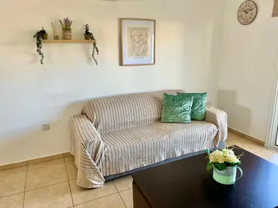 a living room with a couch and a table at Mythical Sands Holiday Apartment in Paralimni