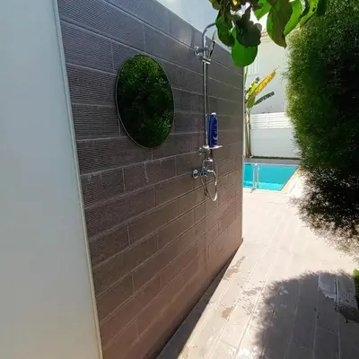 a shower in a brick wall with a round window at Villa Aleksandar in Protaras