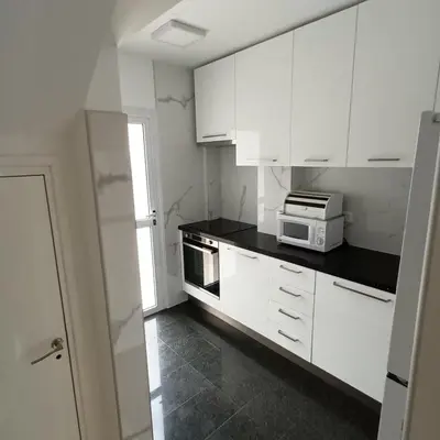a kitchen with white cabinets and a microwave at Villa Aleksandar in Protaras