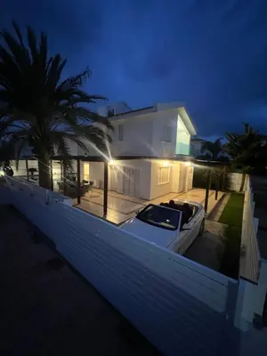 a white house with a boat in front of it at Villa Aleksandar in Protaras