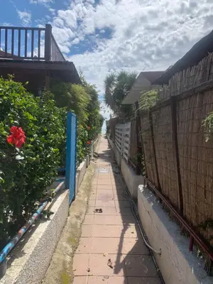 a sidewalk next to a fence in a yard at Leonidas Seaside in Meneou