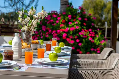 a table with plates of food and drinks on it at Cape Greco Palm Trees Villa in Ayia Napa