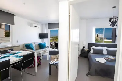 a bedroom and living room with a bed and a table at Sun & Sea Seaview Apartment in Protaras