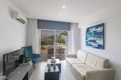 a white living room with a couch and a table at Sun & Sea Seaview Apartment in Protaras
