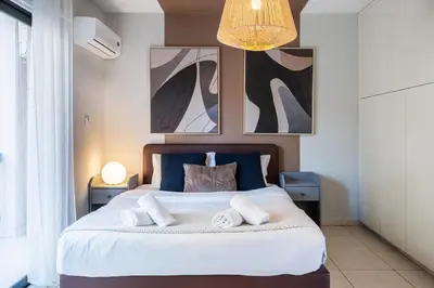 a bedroom with a large bed with two towels at Gitane 1-Bedroom Apartment in Larnaca in Larnaka