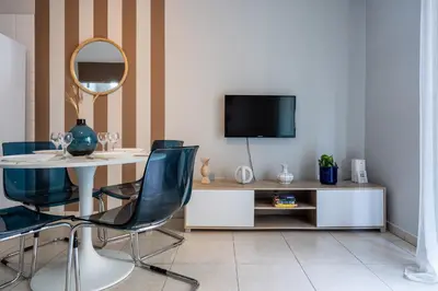 a dining room with a table and chairs and a tv at Gitane 1-Bedroom Apartment in Larnaca in Larnaka