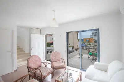 a living room with a couch and chairs and a balcony at Peaceful Cozy Home Great Location in Protaras