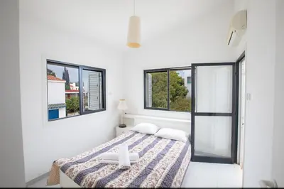 a white room with a bed with a cross on it at Peaceful Cozy Home Great Location in Protaras