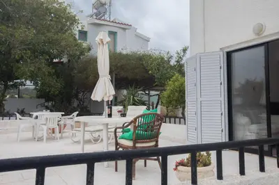 a patio with a table with an umbrella and chairs at Peaceful Cozy Home Great Location in Protaras